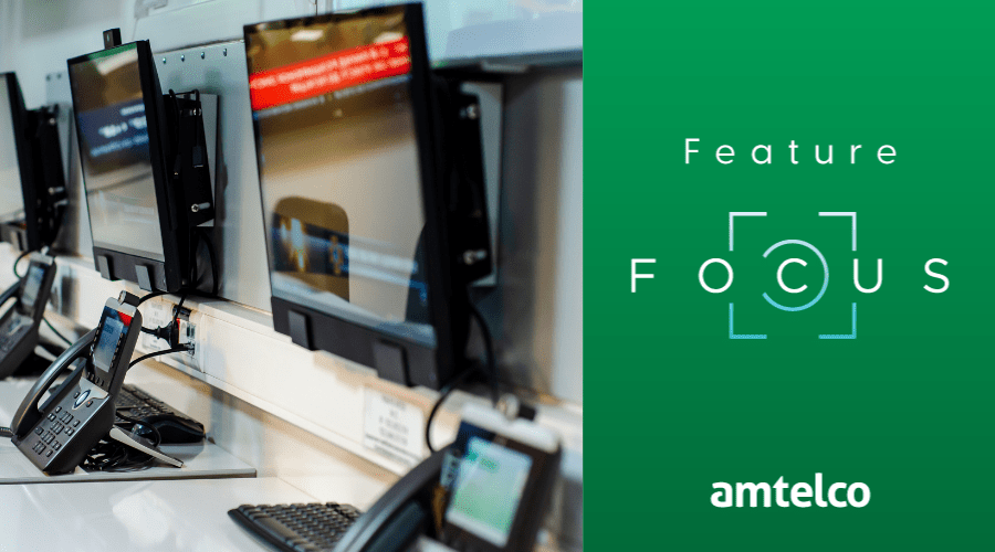 A row of phones and computer monitors in an emergency call center.