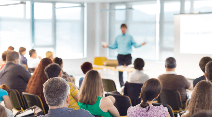 People listening to a speaker at a conference.