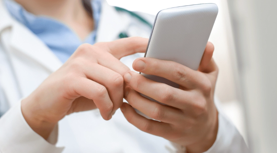 Doctor coordinates patient care by communicating via her cell phone.