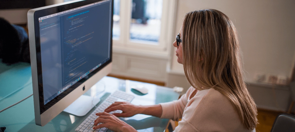 Woman coding MergeComm for inbound and outbound actions.