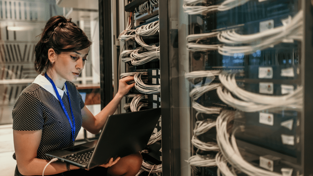 A woman works in a server room.