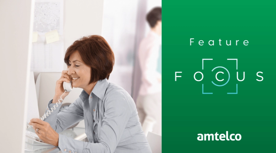 A woman talks on a landline phone.