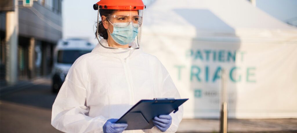 A nurse in PPE waits to help her next COVID-19 patient.