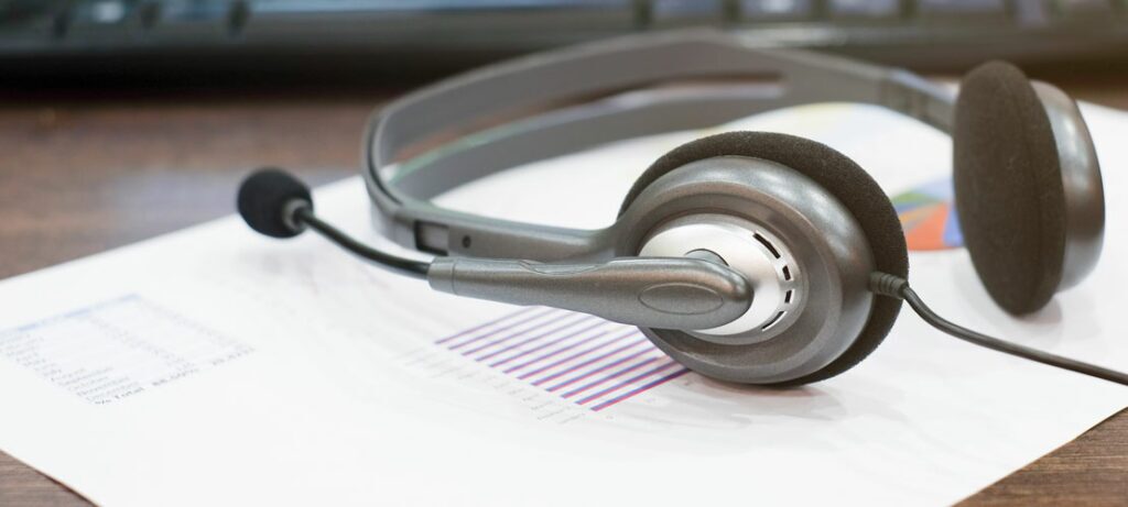 A headset rests on a call center report.