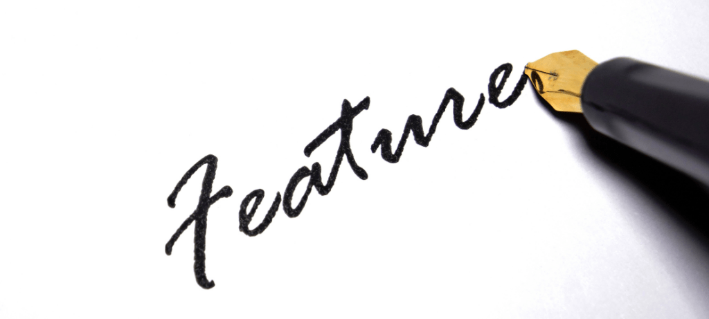 A pen writes the word "feature."