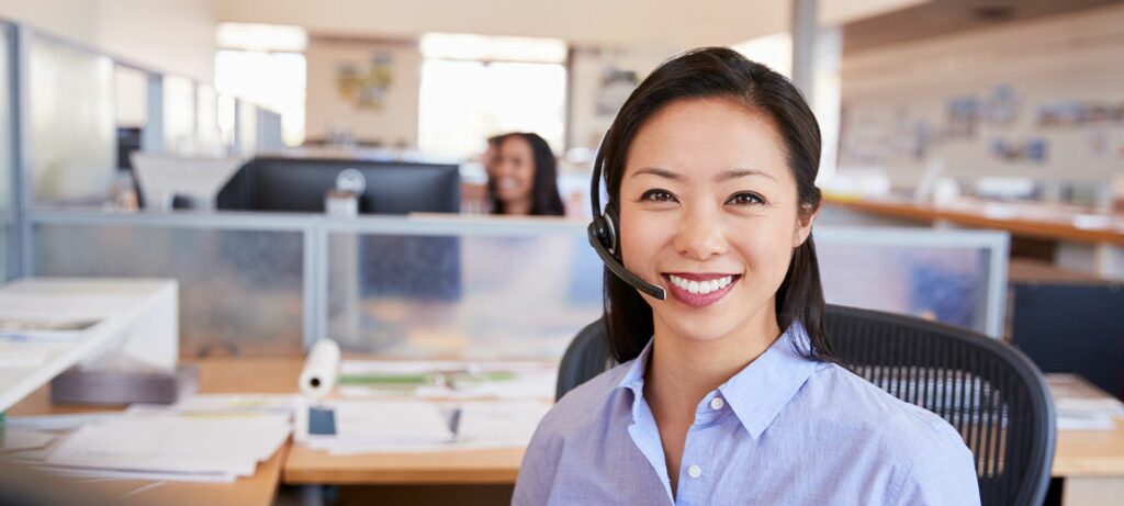 Smiling female call center agent assisting customers