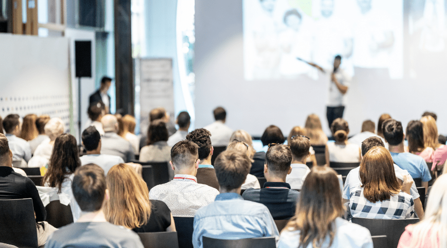 A group of people attend a conference.