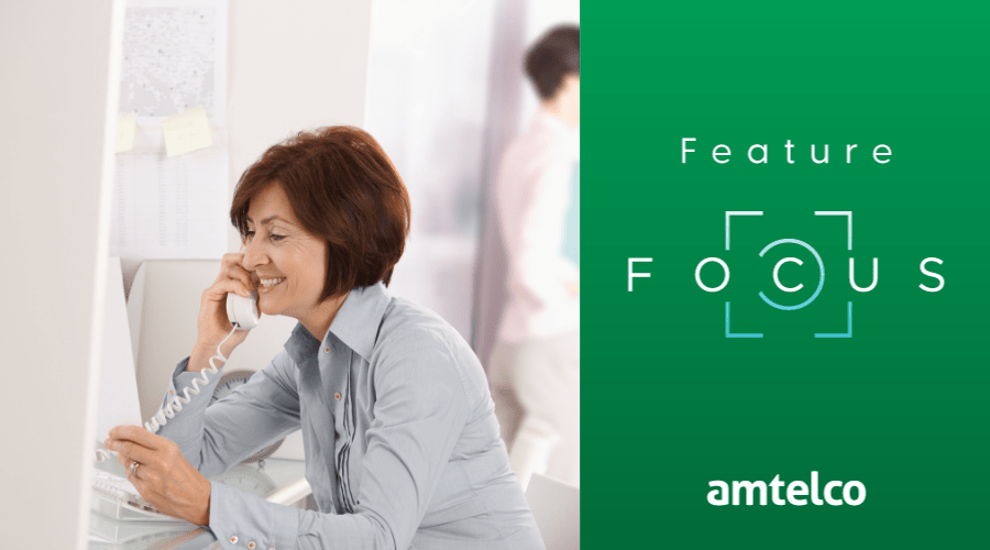 A woman talks on a landline phone.