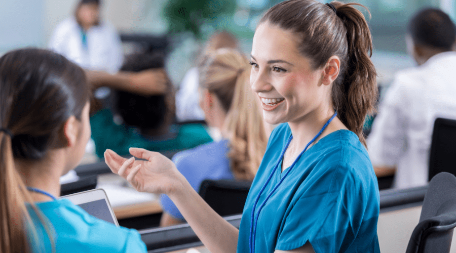 Nurses talk during a patient handoff.