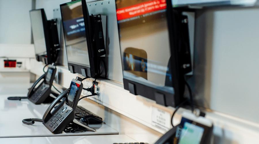 A line of call center phone and monitors.