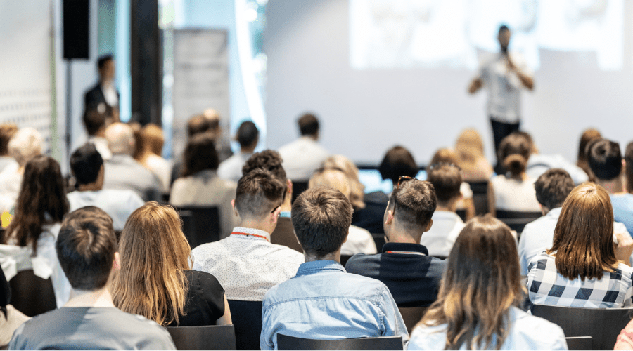 Group of people listening to a speaker at a conference.