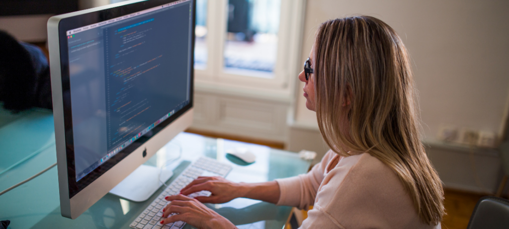 Woman coding MergeComm for inbound and outbound actions.