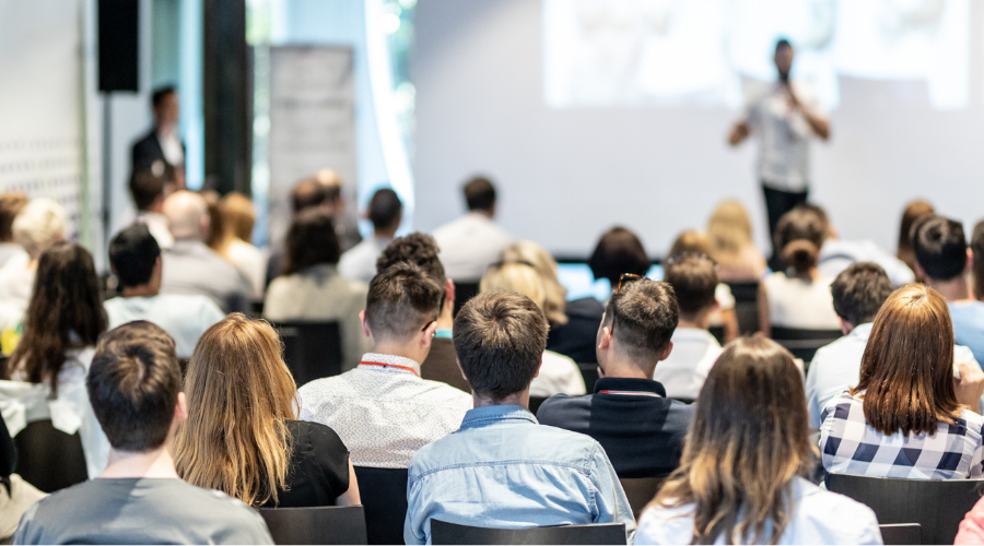 Group of people listening to a speaker at a conference.