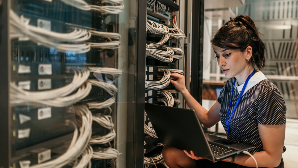 A woman works in a server room.