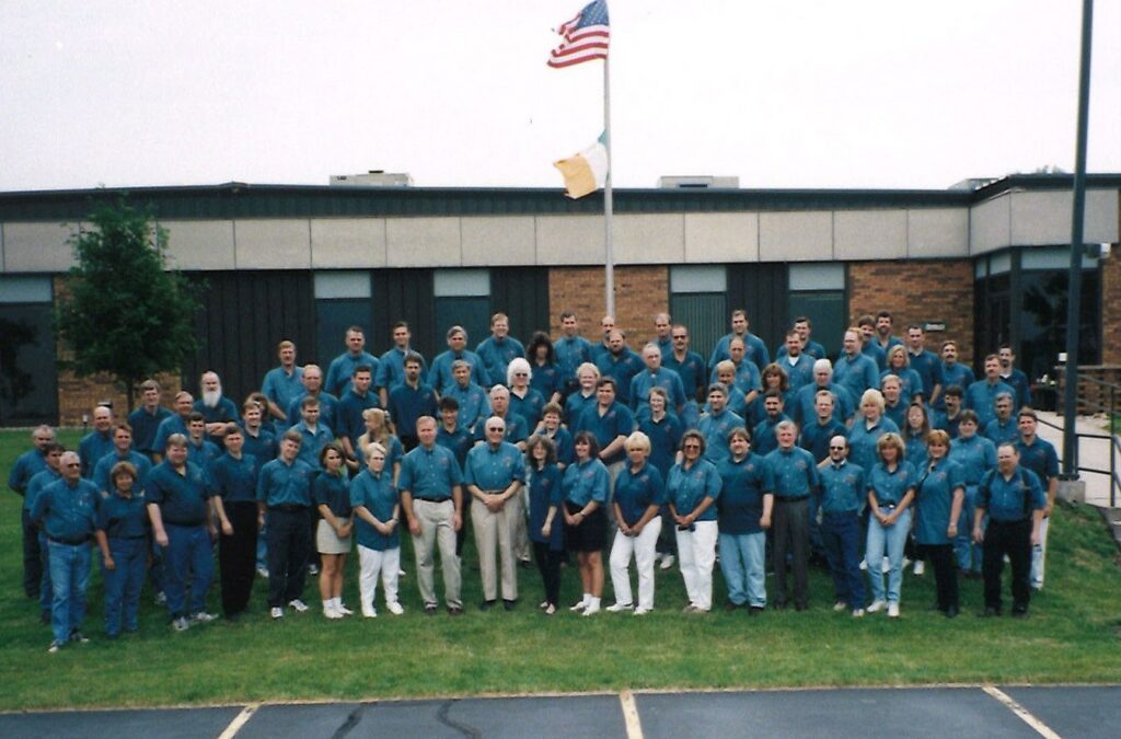 Amtelco employees wear green in this company photo with Mr. C. Green is still Amtelco's signature color and is a prominent reminder of Amtelco's Irish heritage.