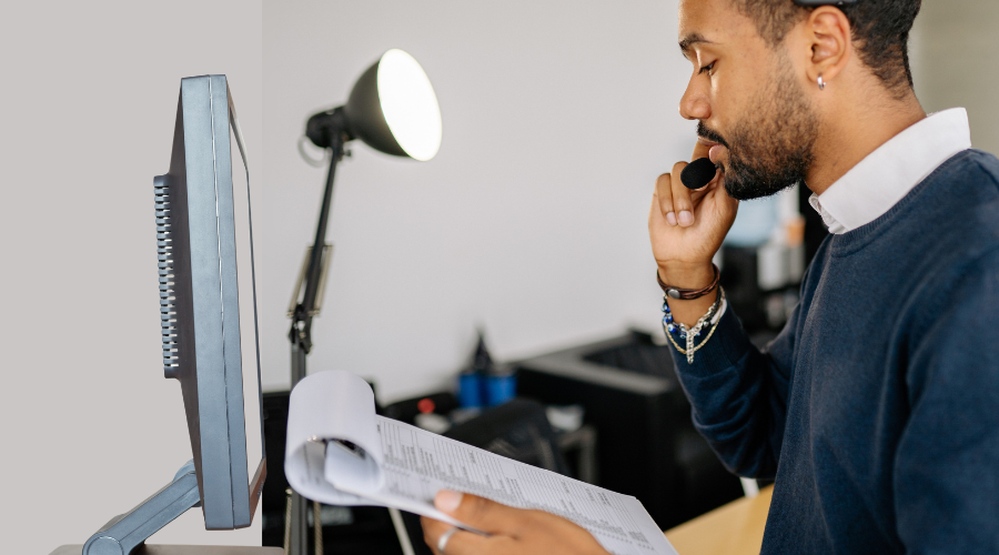 A switchboard agent uses a paper spreadsheet.